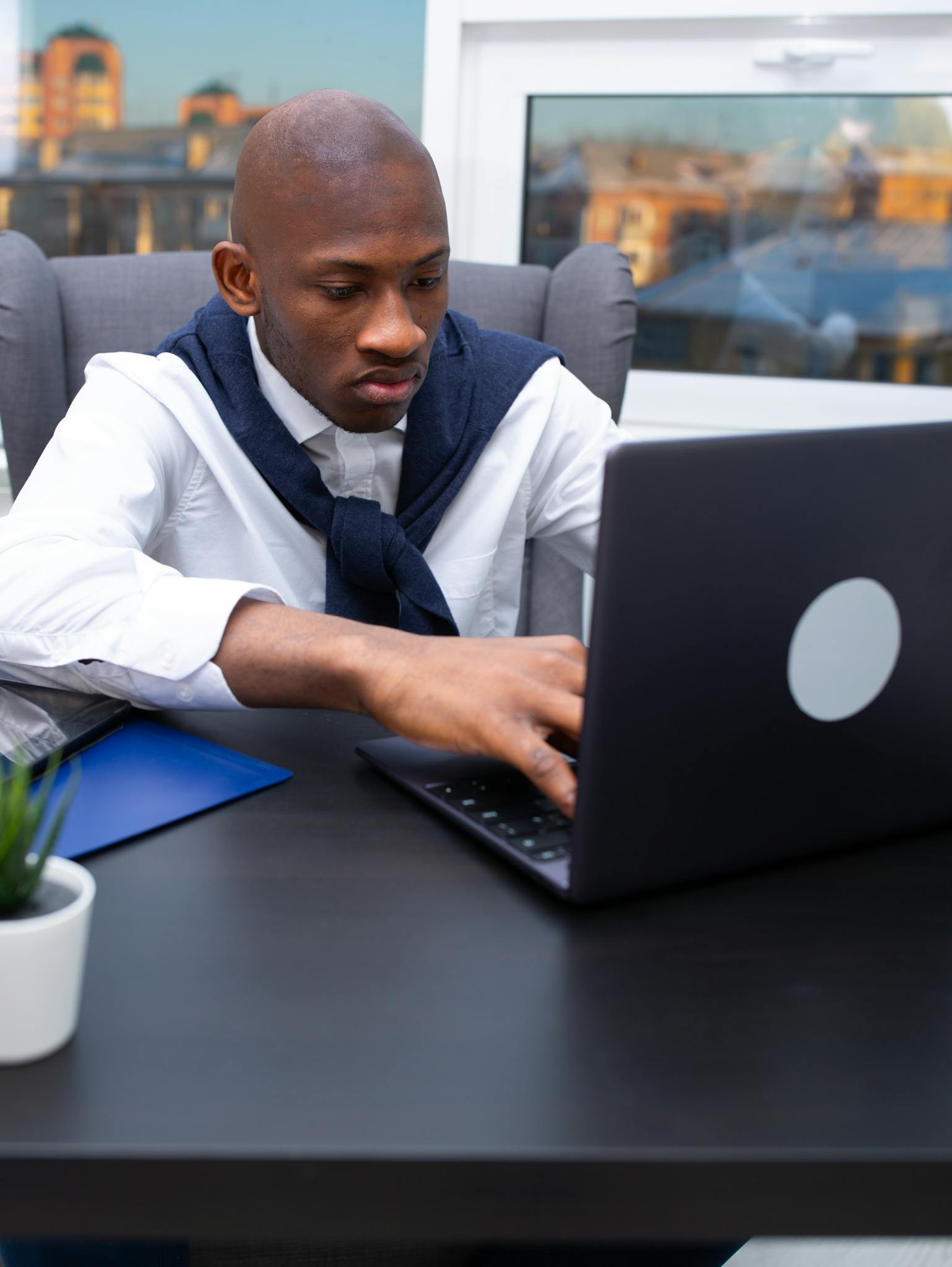 Professional businessman concentrating on laptop work in a modern office setting.